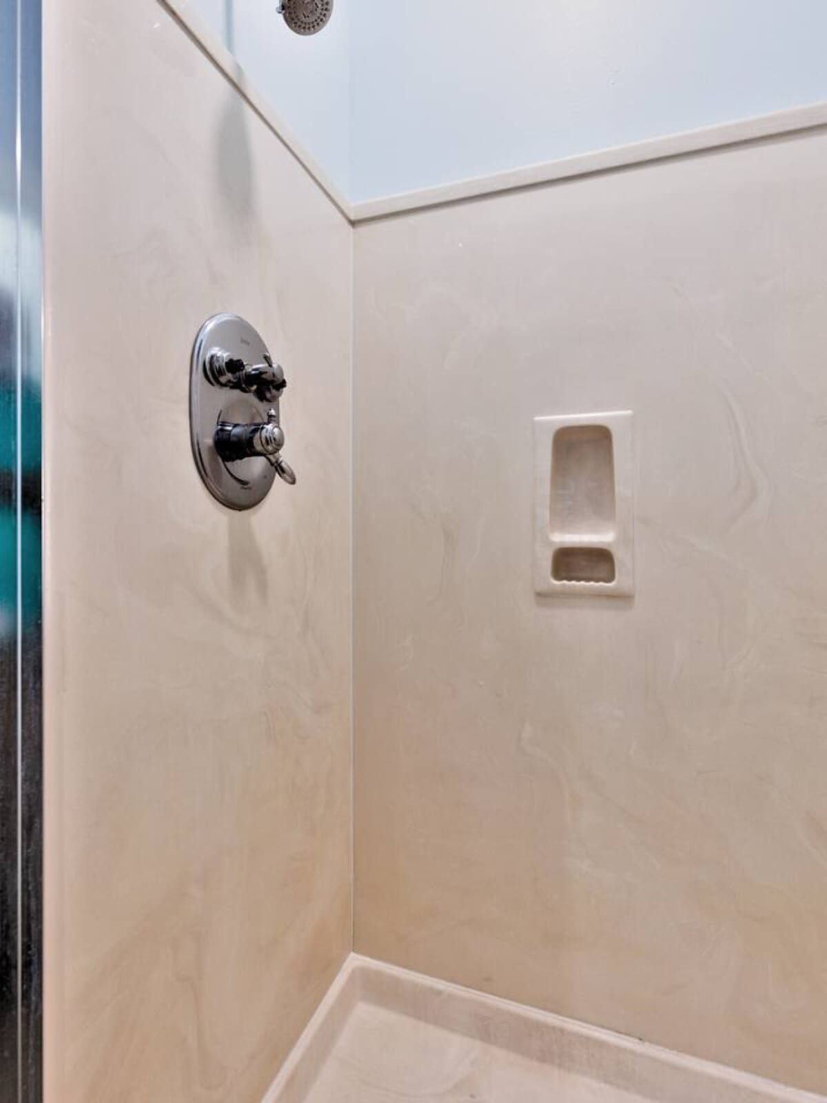 This freshly tiled shower has all the clean, modern vibes with those sleek fixtures and built-in niche, ready to rinse off the sand and salt after a day at the beach.