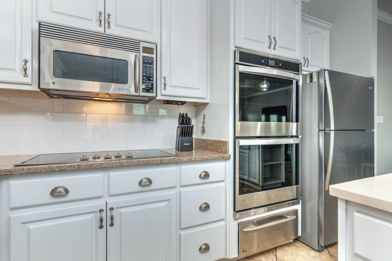 This kitchen is basically a chef's dream with all that stainless steel, double ovens, and granite countertops—perfect for cooking up something amazing or just admiring the view while someone else does the heavy lifting.
