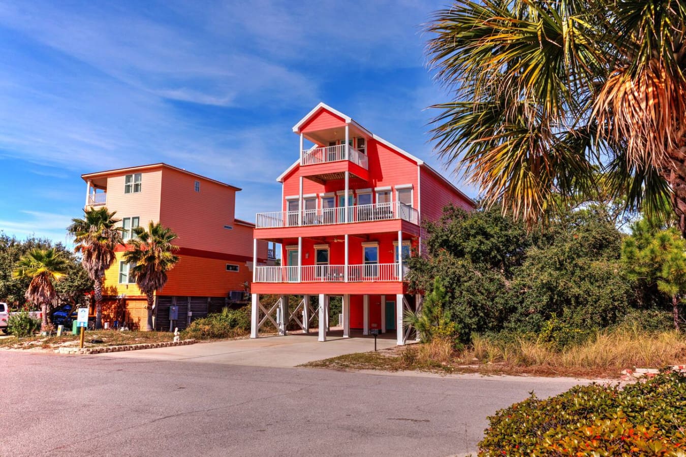 This striking red beach house sits three stories tall with plenty of decks to soak in the view, and it's basically the showstopper of this colorful coastal neighborhood.