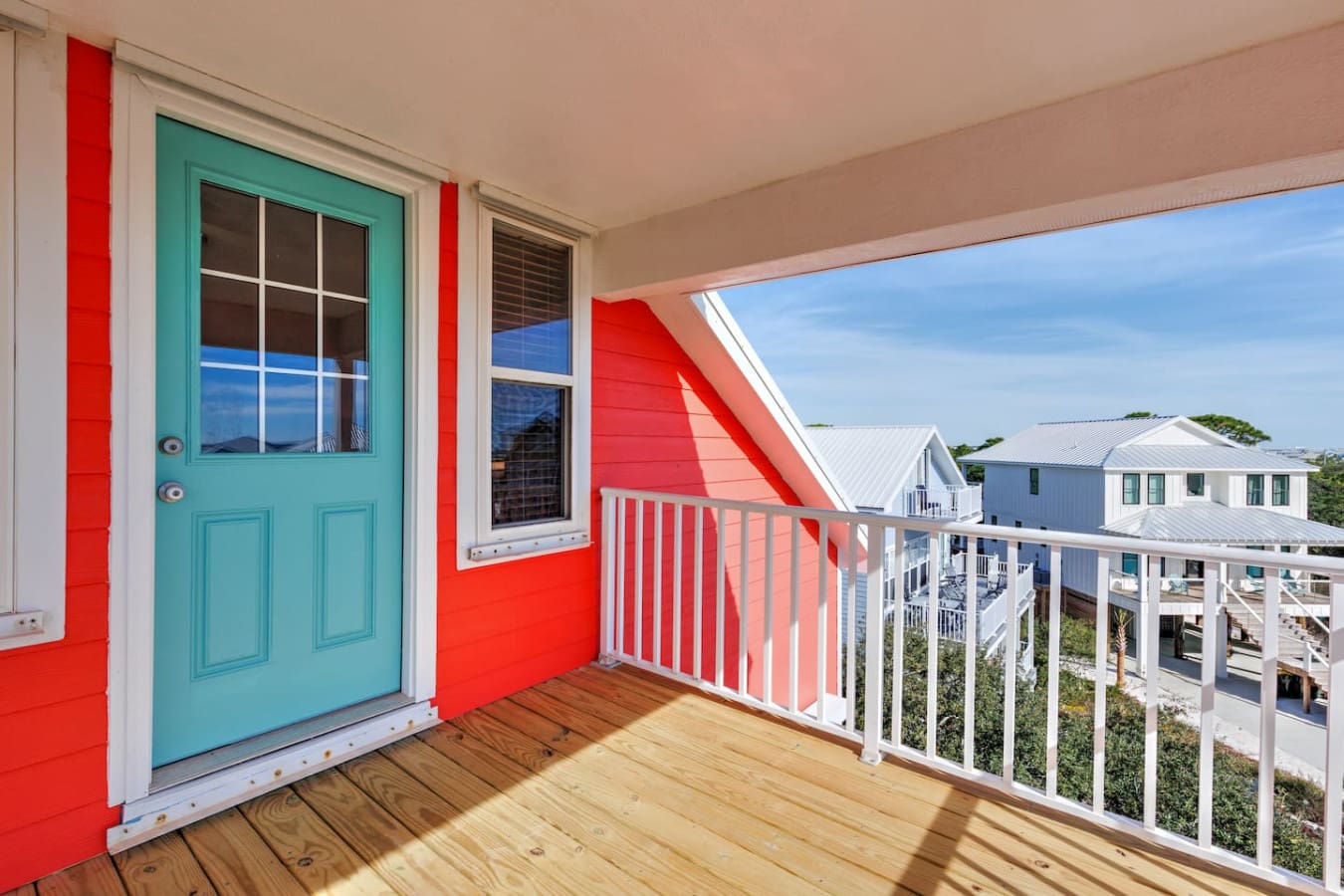 Step out onto this bright turquoise-doored deck and you've got sweeping views of the whole colorful beach community, plus that perfect mix of sun and shade to make it your favorite spot all day long.