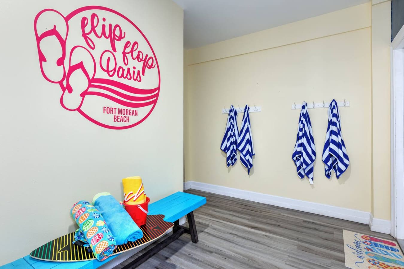 This cute flip-flop-themed changing area with those blue and white striped towels hanging up is basically saying "beach day ready" before you even step outside.
