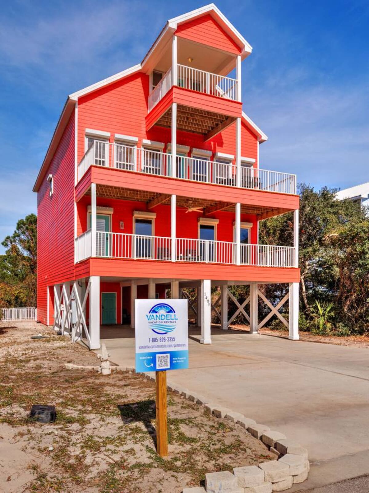 This bold red three-story beach house is basically impossible to miss with its stacked decks and that signature coastal charm that screams "bring your whole crew and stay awhile."