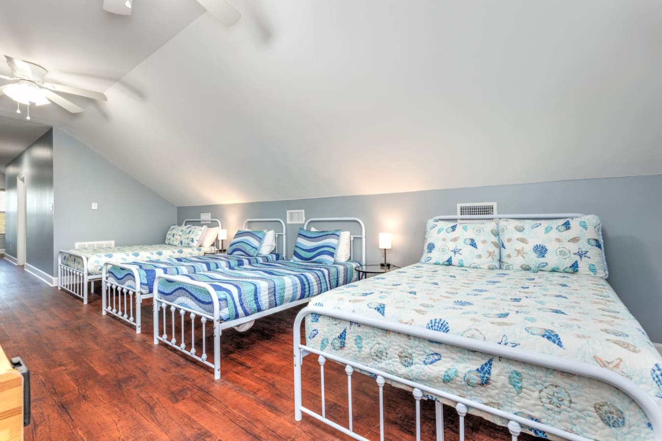 This spacious attic bunkroom is basically the perfect setup for the whole crew with multiple beds, that ocean-themed bedding, and enough room for everyone to crash comfortably after a long beach day.