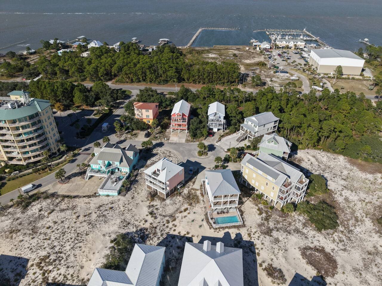 This beachfront community is packed with character—colorful homes scattered across the dunes, a marina in the distance, and enough space between neighbors to feel like you've got your own little slice of the coast.
