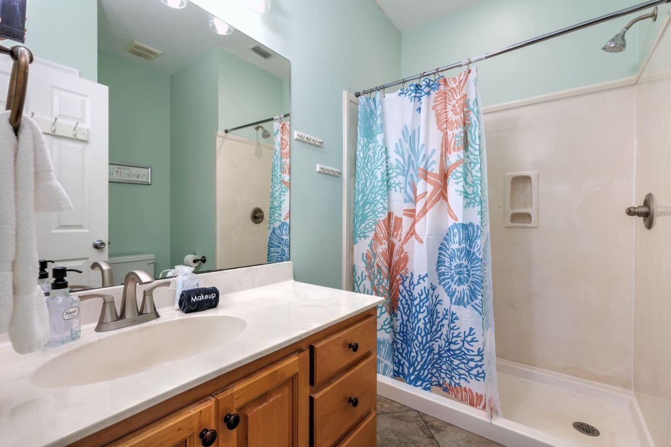 This mint-green bathroom with its coral and teal sea-life shower curtain is basically a little coastal escape every time you step inside.