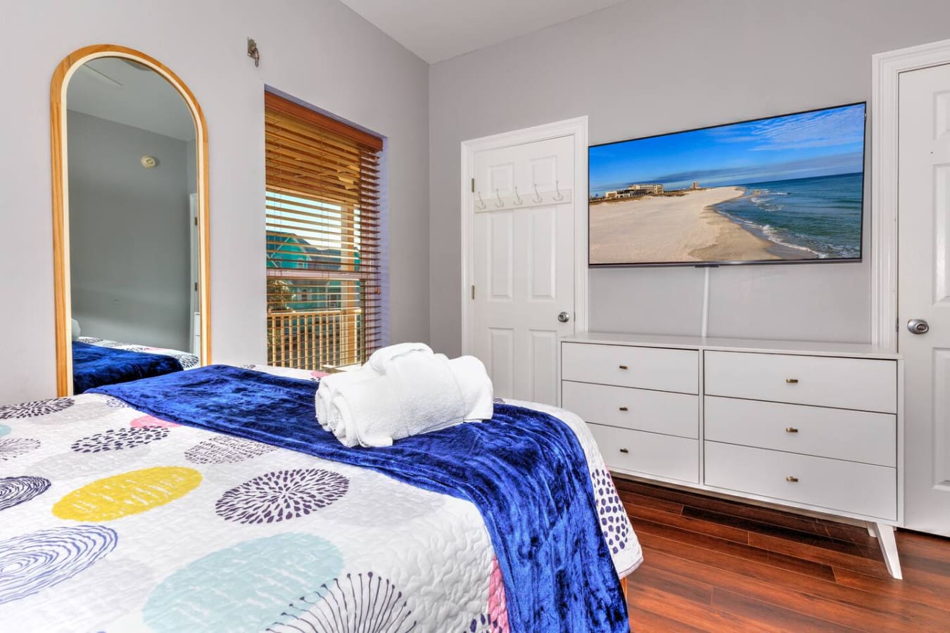 This bright, beachside bedroom has everything you need to feel totally relaxed—soft coastal vibes, a flat-screen view of that gorgeous sandy shoreline, and plenty of natural light streaming through those wood shutters.