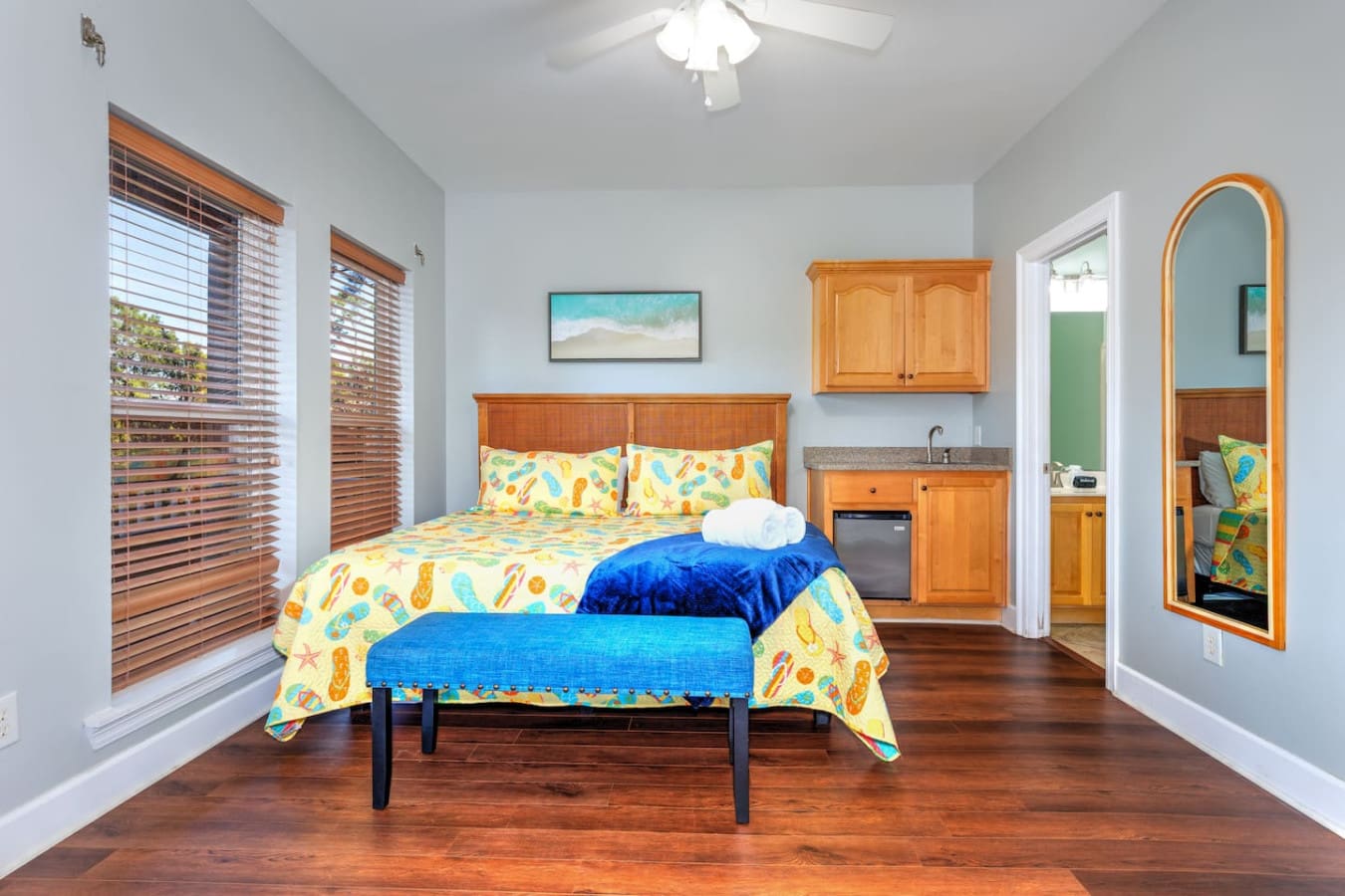 This spacious master suite has all the coastal charm you could want with that fun beachy bedding, wood furniture, and its own little kitchenette tucked in the corner for those lazy mornings.