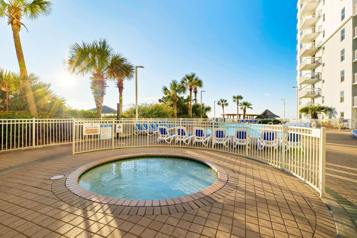 Soak in this cozy hot tub tucked into the resort grounds while palm trees frame the view and the main pool sparkles just beyond—it's the kind of hidden gem spot that makes you feel like you've found your own private retreat.