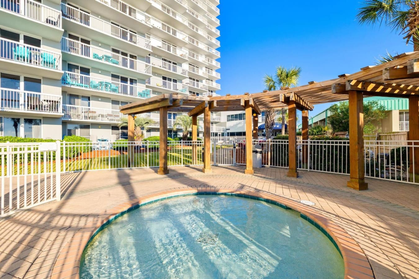 Lounge under the wooden pergola's dappled shade, dip into the sparkling pool whenever you want, and let the whole resort setup make you feel like you're living the beach life without ever leaving the grounds.