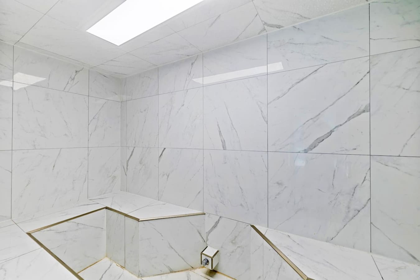 This pristine marble shower enclosure is basically a spa moment waiting to happen—all that natural light, clean lines, and luxe finishes make it feel like you're washing away the day in style.