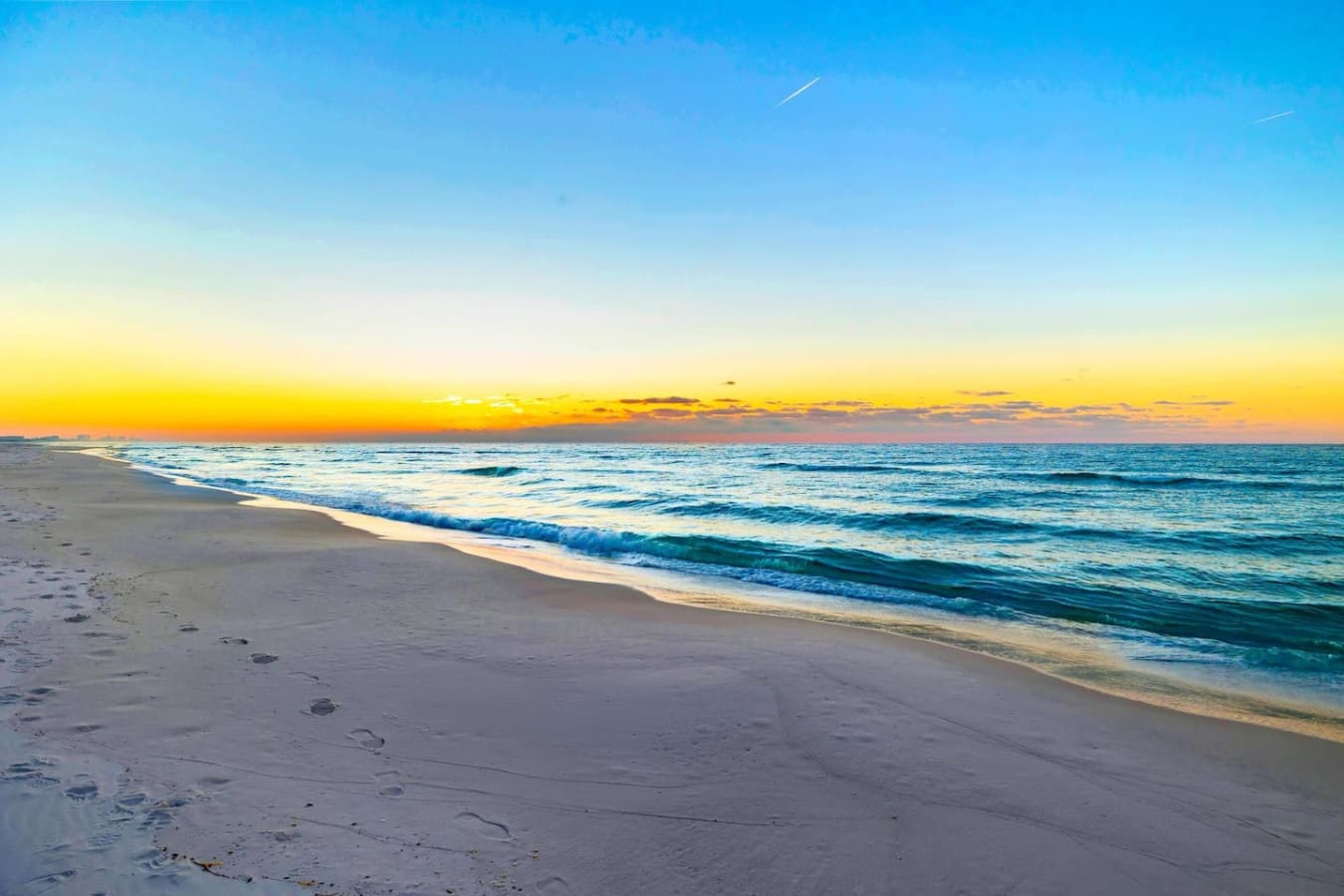 There's something about having the entire beach to yourself at sunrise—footprints in the sand, waves rolling in soft and easy, and that golden light hitting the water like it was made just for this moment.