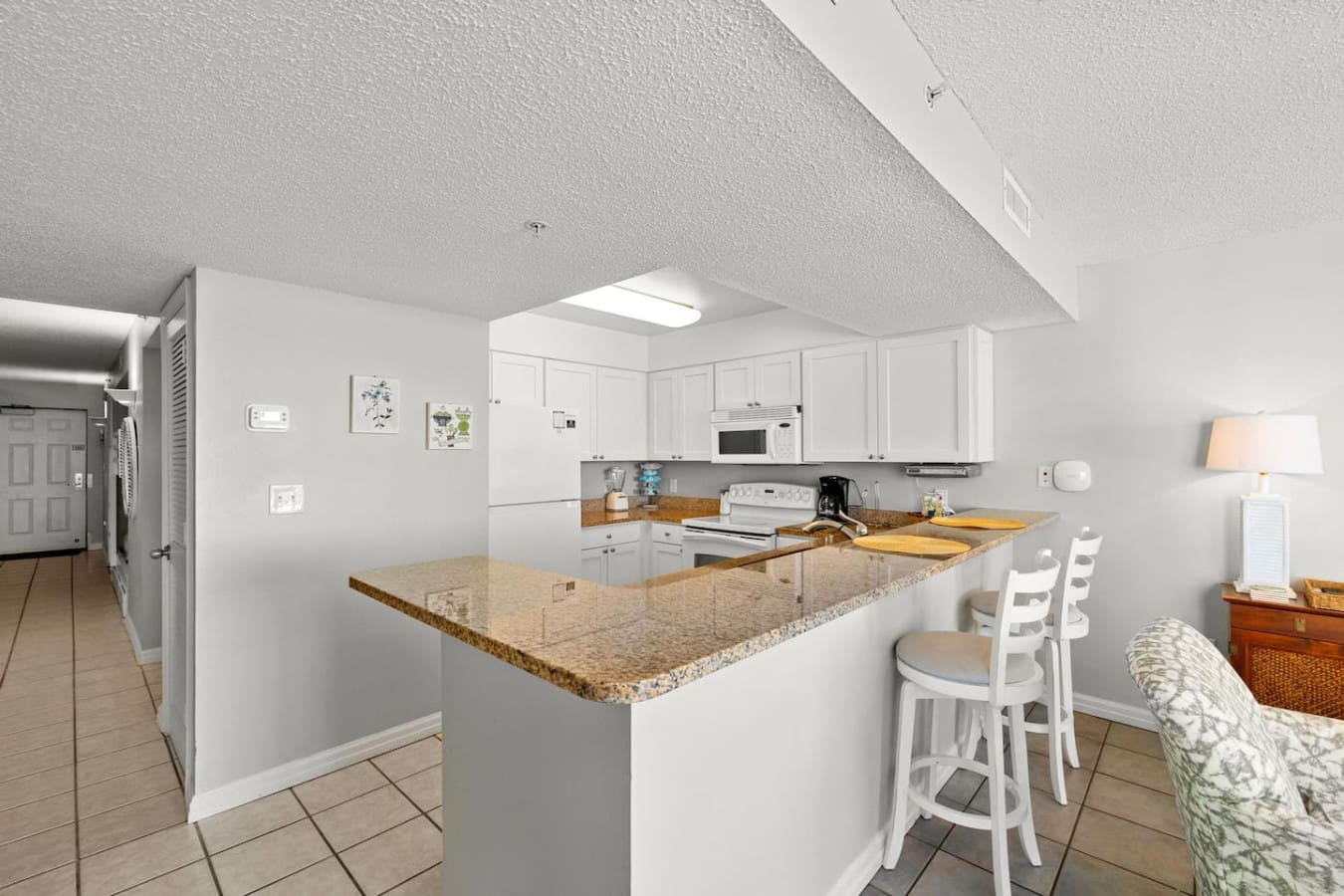 The granite island in this fully equipped kitchen is basically the heart of the place—plenty of counter space to prep, cook, or just perch on those bar stools with your coffee while you map out your beach day.