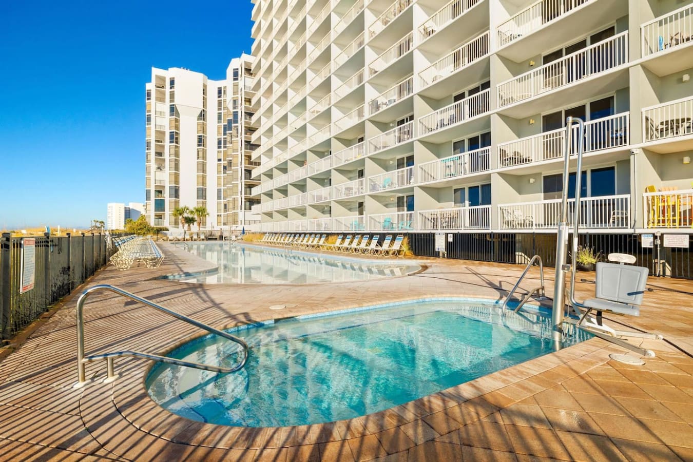 Lounge by the main pool with the whole resort stretched out in front of you—the kind of setup where you can bounce between the water, the shade, and those oceanfront vibes without ever really leaving your spot.