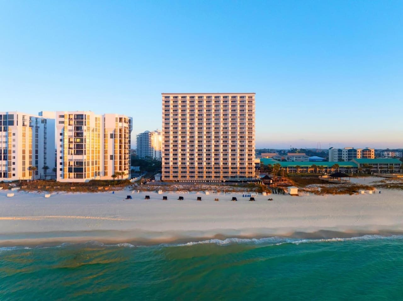 Watch the golden hour paint the beachfront in warm light while you're steps away from the sand—this is what every beach vacation should feel like.