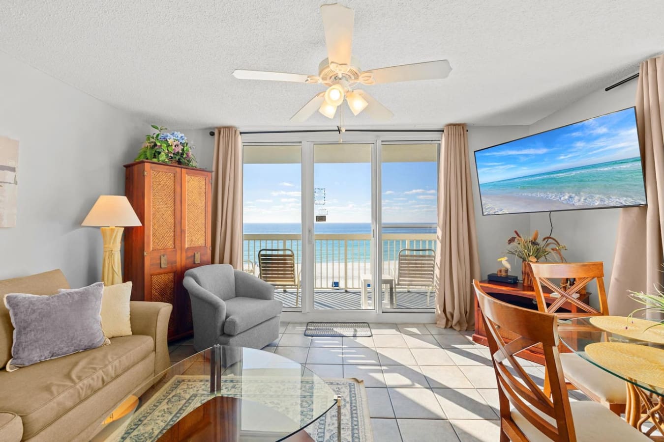 Watch the ocean shimmer from your private balcony while the ceiling fan keeps things breezy—this is the kind of living room view that makes you forget you ever had anywhere else to be.