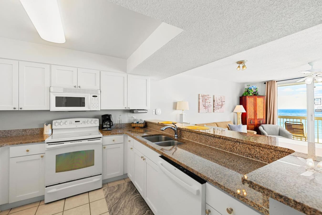 The fully equipped kitchen flows straight into your living space with those granite counters and ocean views, so you can whip up whatever you want and never miss a beat of that beachfront scene playing out beyond your windows.