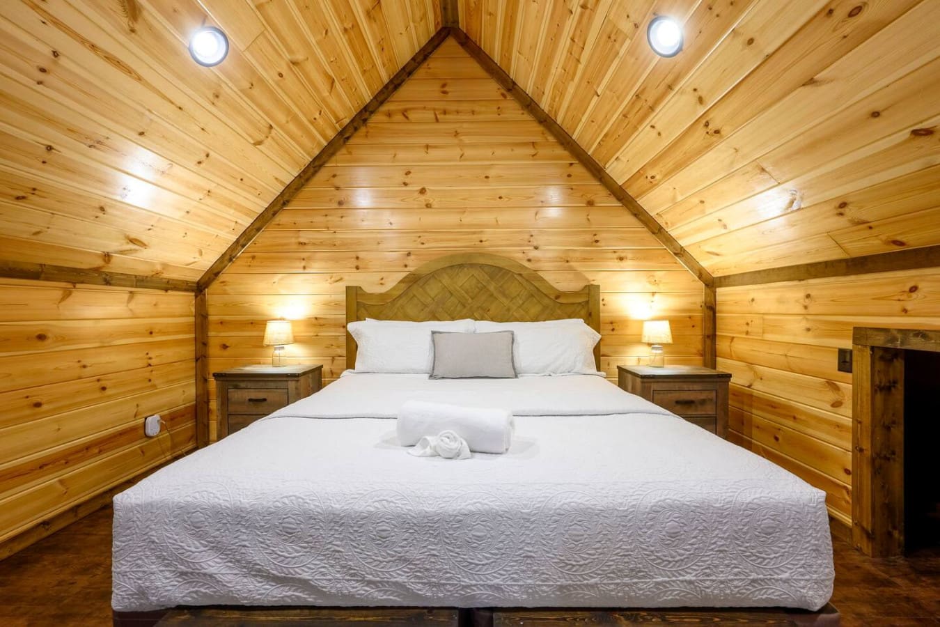 Cozy loft bedroom with vaulted wood ceilings and ambient lighting perfect for a peaceful night's sleep.
