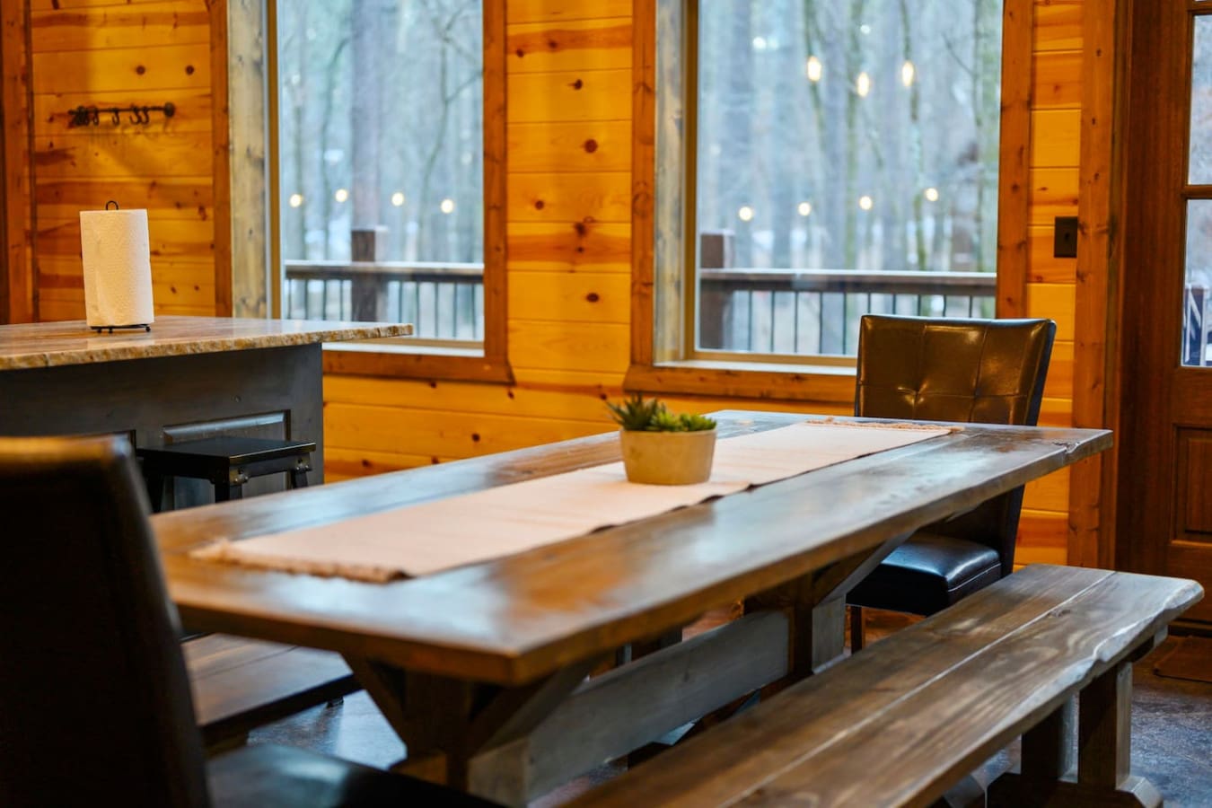 This cozy wood cabin dining area has gorgeous forest views and plenty of natural light through those big windows.