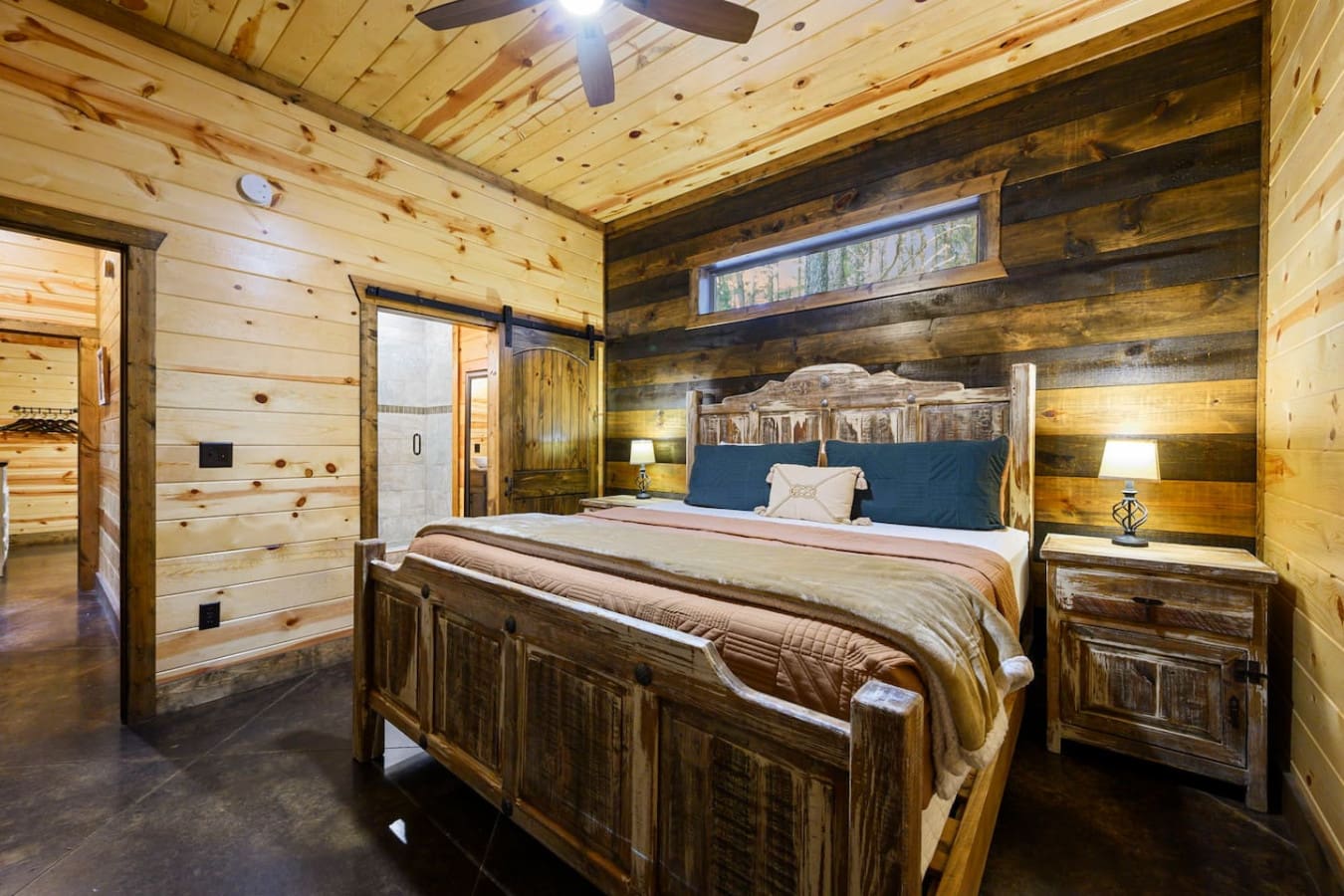 This cozy log cabin bedroom features rustic wood beams, a sturdy timber bed, and plenty of natural light from overhead windows.