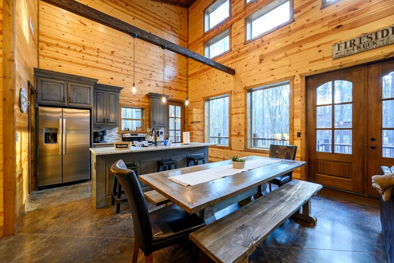 This gorgeous open-concept log cabin has soaring ceilings, a chef's kitchen, and windows overlooking the forest from every angle.