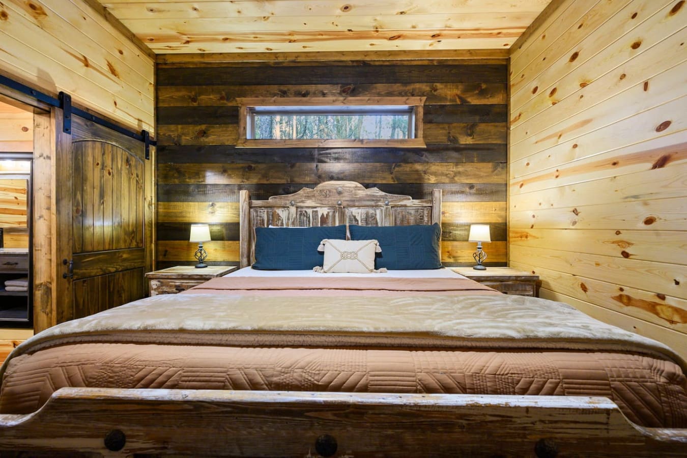 This cozy log cabin bedroom has everything—rustic charm, a gorgeous bed, and those forest views right through the window.