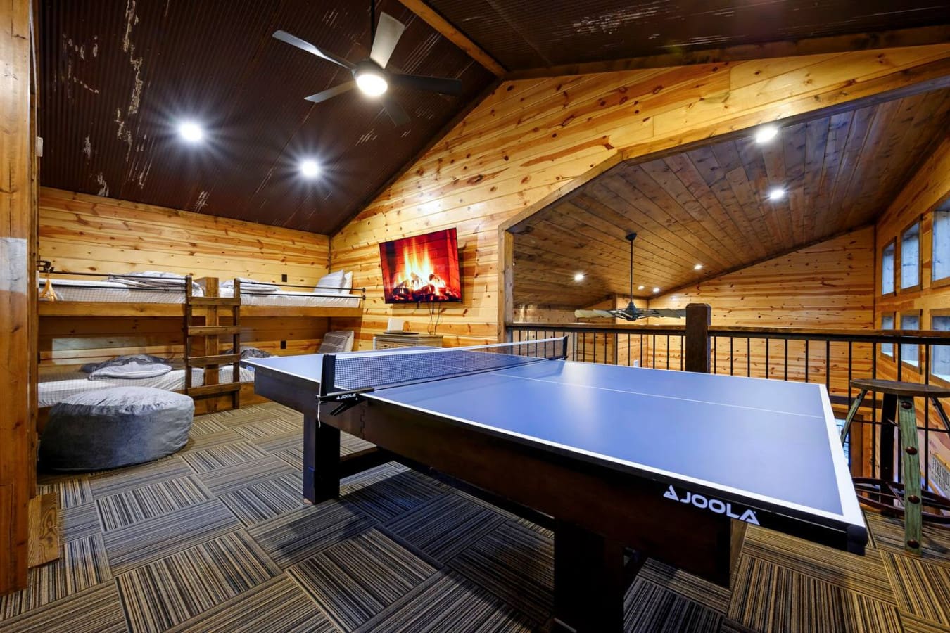 This game room has everything you need for indoor fun—ping pong, bunk beds, and a cozy fireplace.