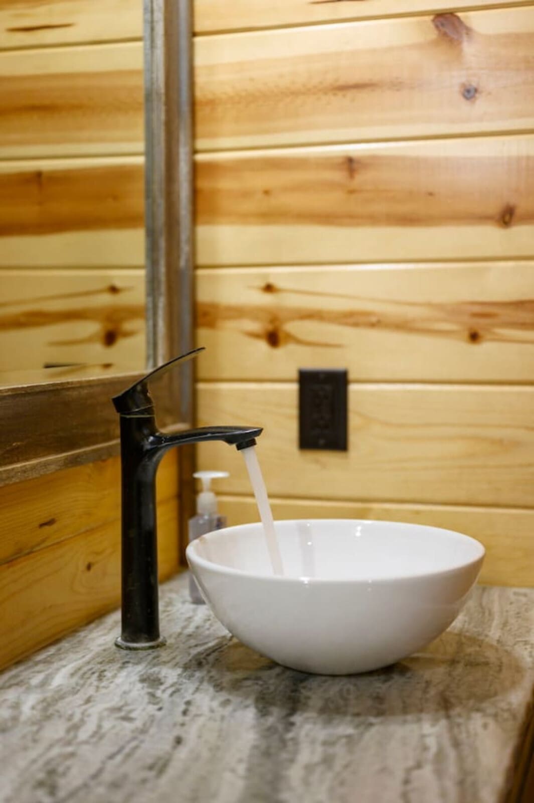 Clean modern bathroom with rustic wood walls and a sleek vessel sink that's totally Instagram-worthy.