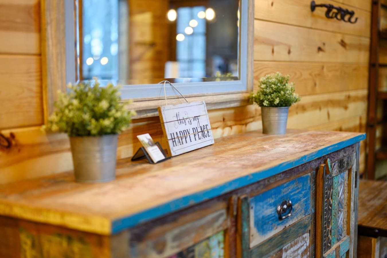 Cozy wooden cabin with rustic blue accents and a mirror overlooking the evening lights outside.