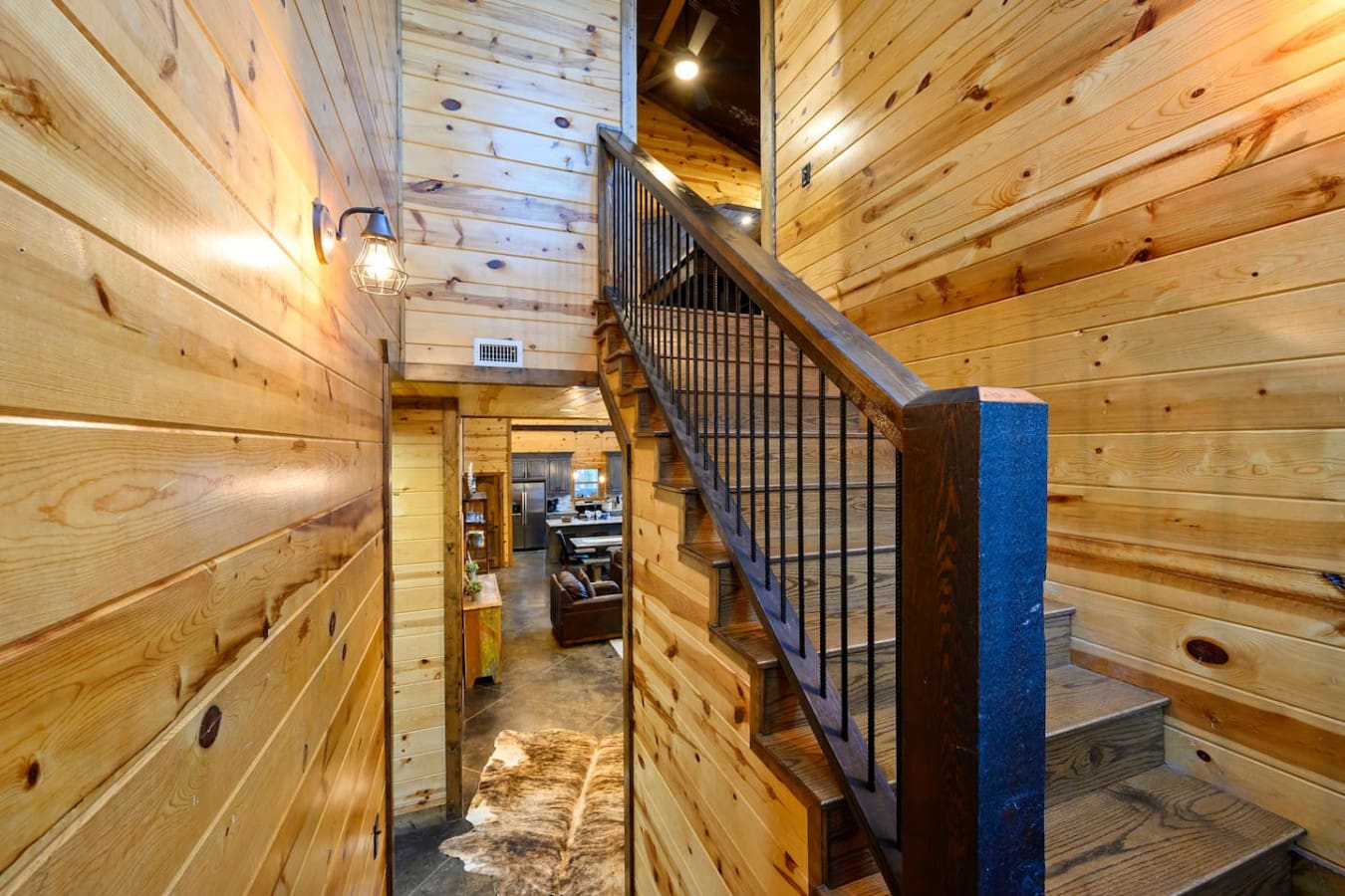 Gorgeous wooden cabin interior with a cozy loft staircase and soaring vaulted ceilings that feel super spacious and inviting.