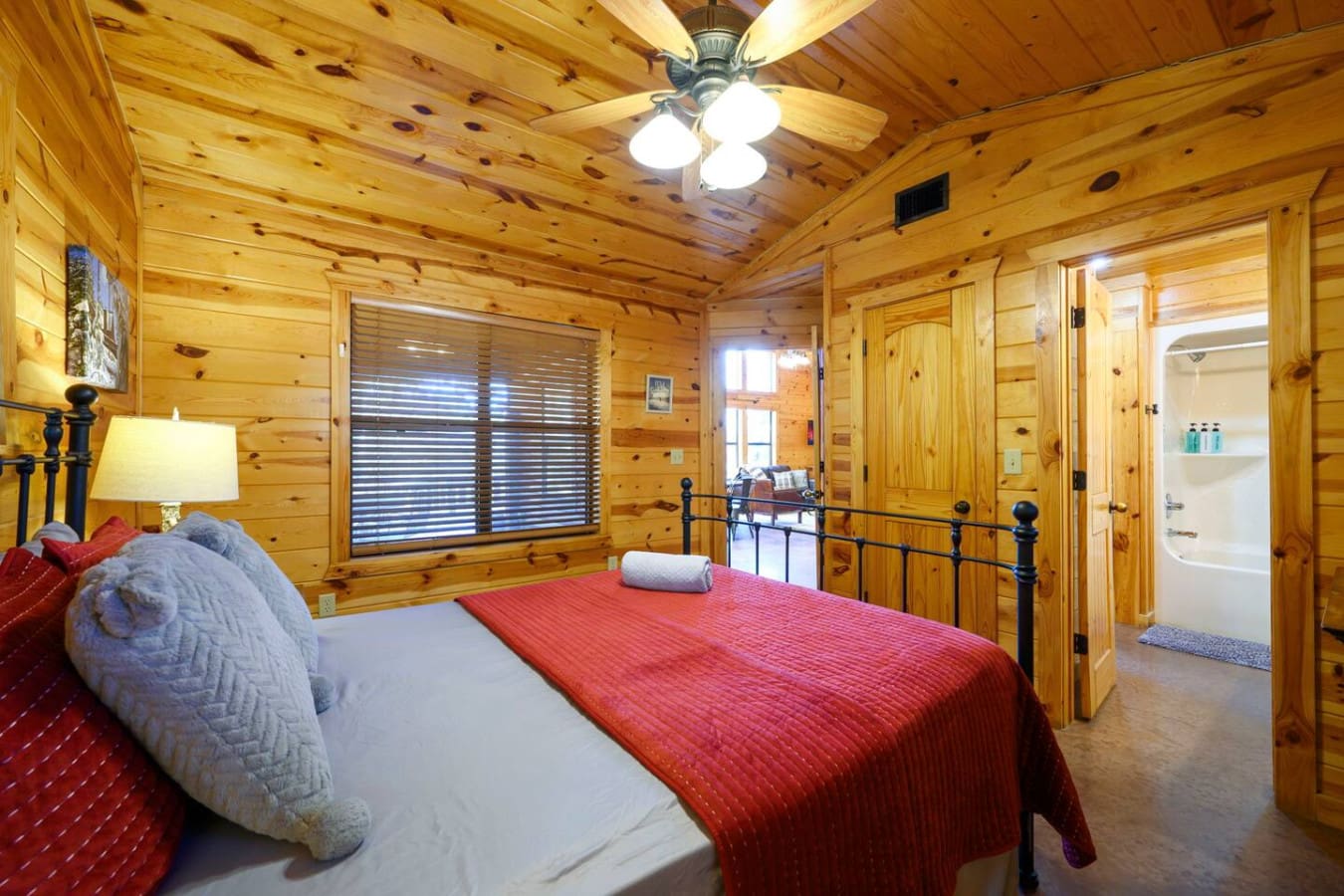 This cozy log cabin bedroom features a comfy queen bed, private ensuite bathroom, and tons of natural wood charm.