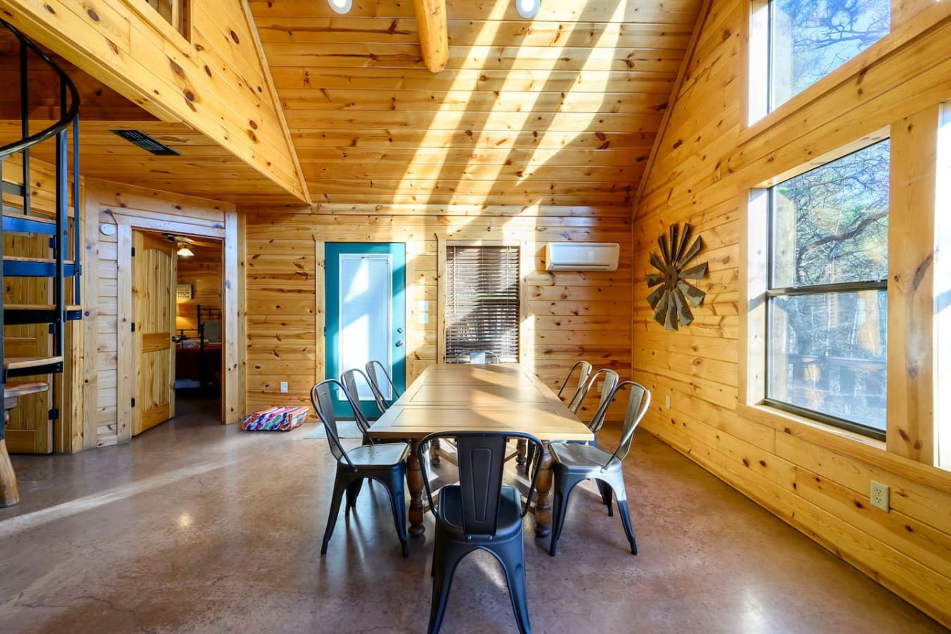 This gorgeous wooden cabin interior floods with natural light and features a spacious dining area perfect for gathering.
