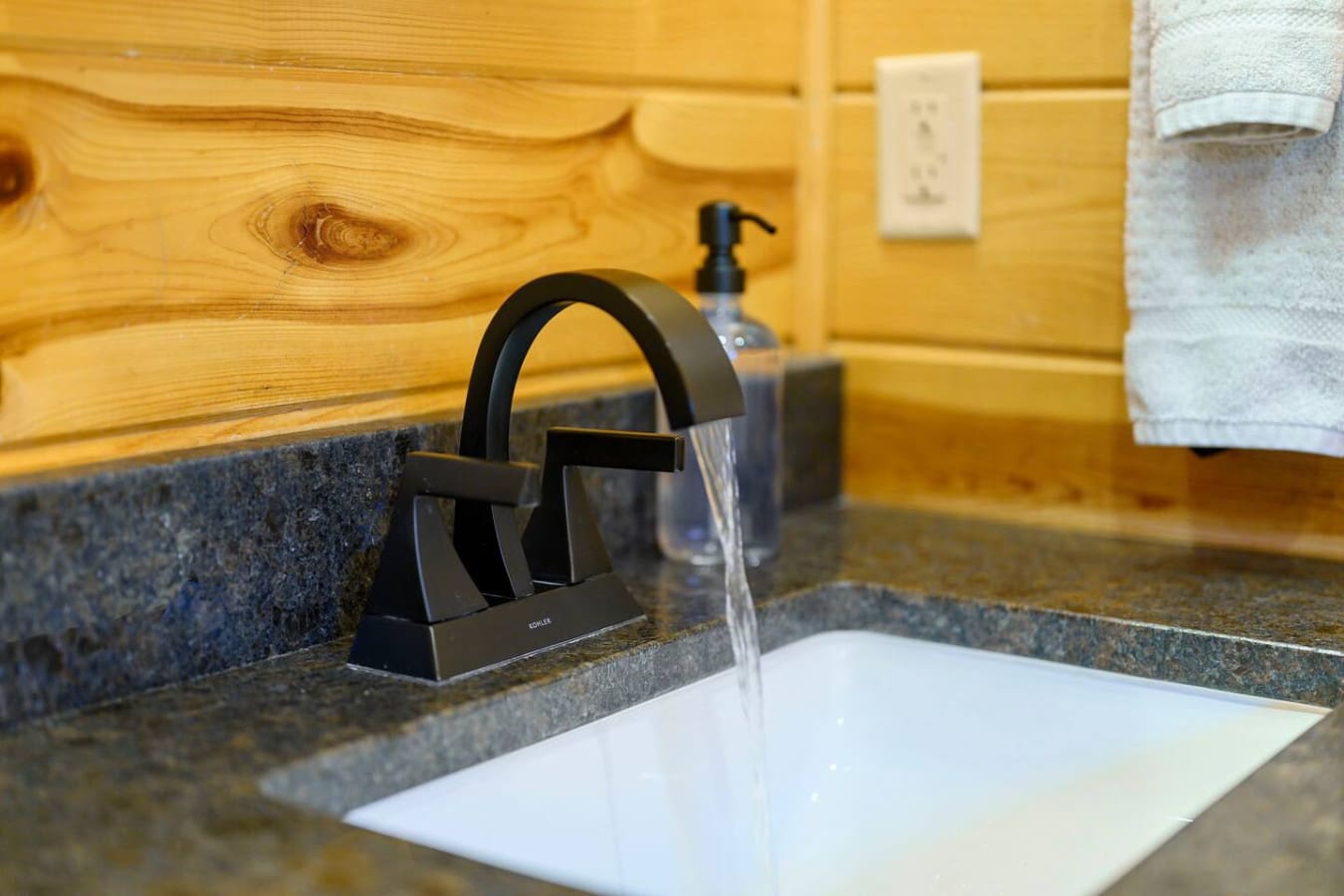 Modern black fixtures and granite countertops make this bathroom sink area feel sleek and upscale.