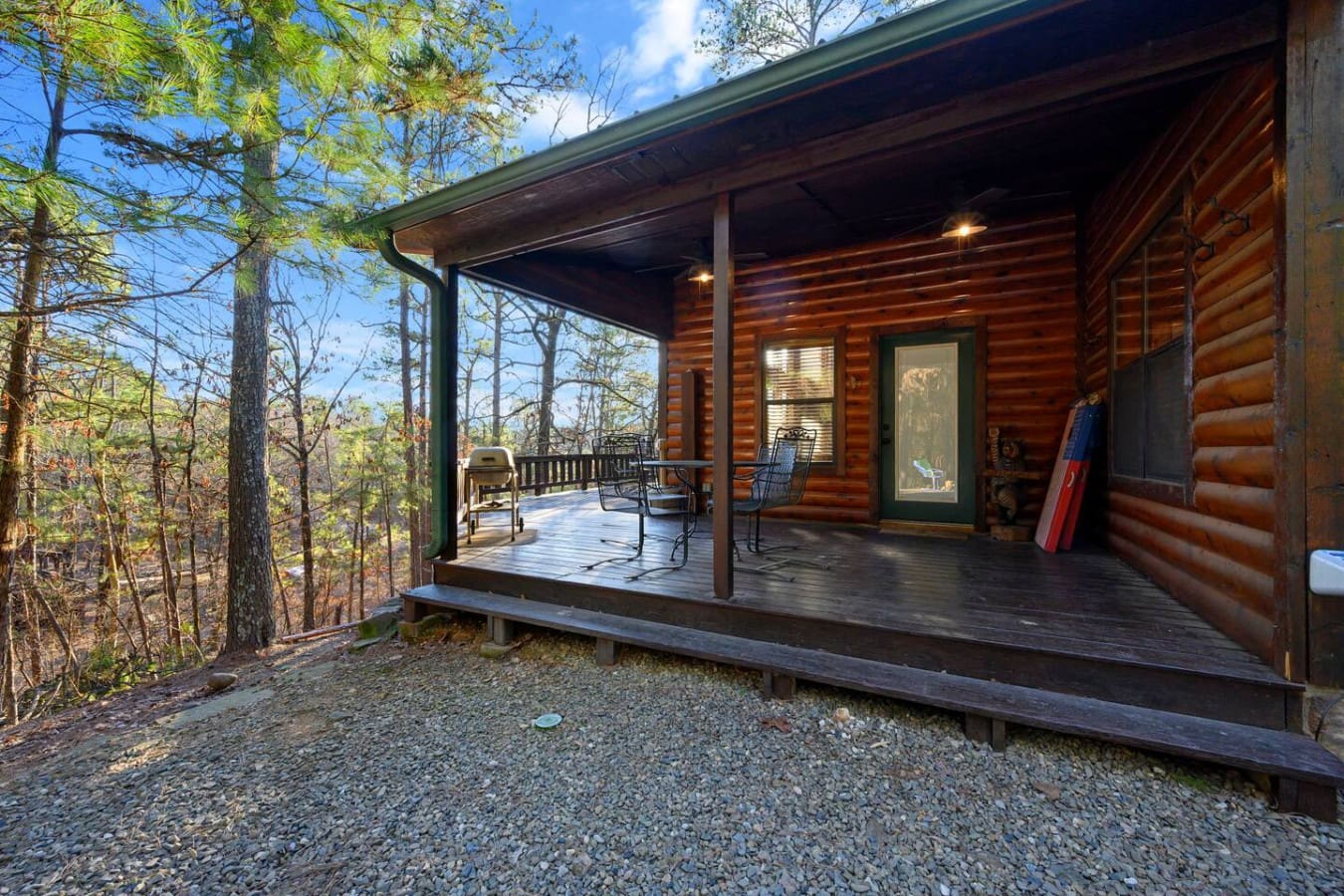 This cozy log cabin offers a spacious wraparound deck nestled in the peaceful woods with stunning forest views.