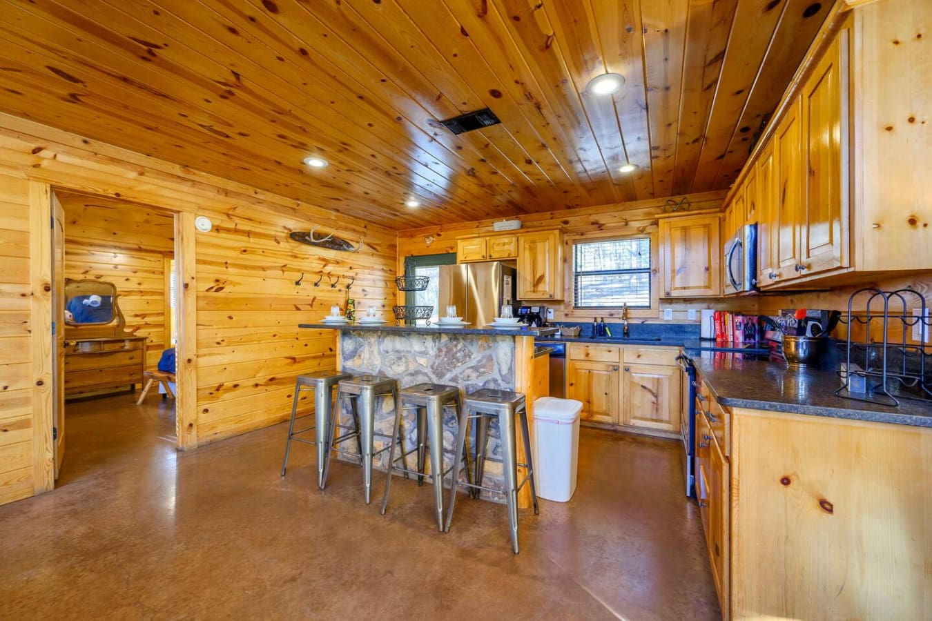 This spacious log cabin kitchen features plenty of counter space, modern stainless steel appliances, and a cozy island perfect for gathering.