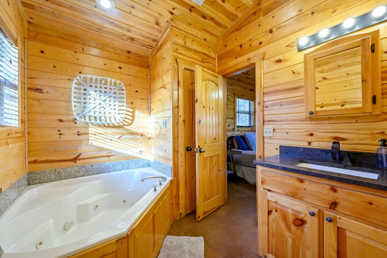 This luxe cabin bathroom features a jetted soaking tub, double vanity, and gorgeous knotty pine throughout.