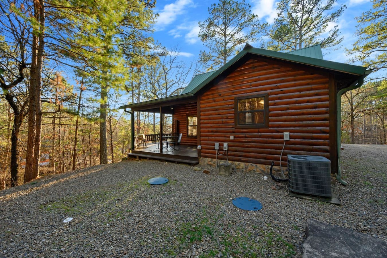 Cozy log cabin nestled in the woods with a spacious front porch and peaceful forest views.
