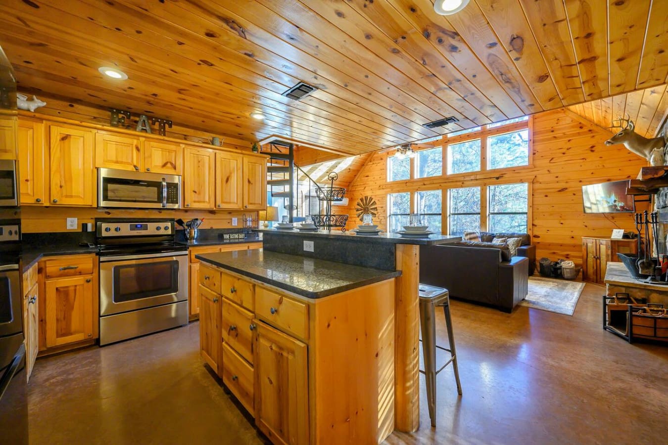 This stunning log cabin kitchen opens straight into the living area with massive windows overlooking the trees.