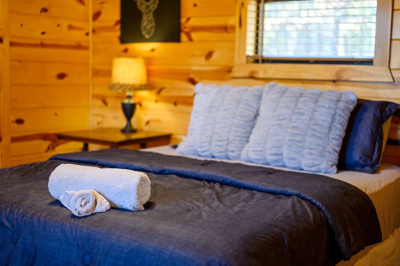 Cozy log cabin bedroom with plenty of natural light and views overlooking the mountains.