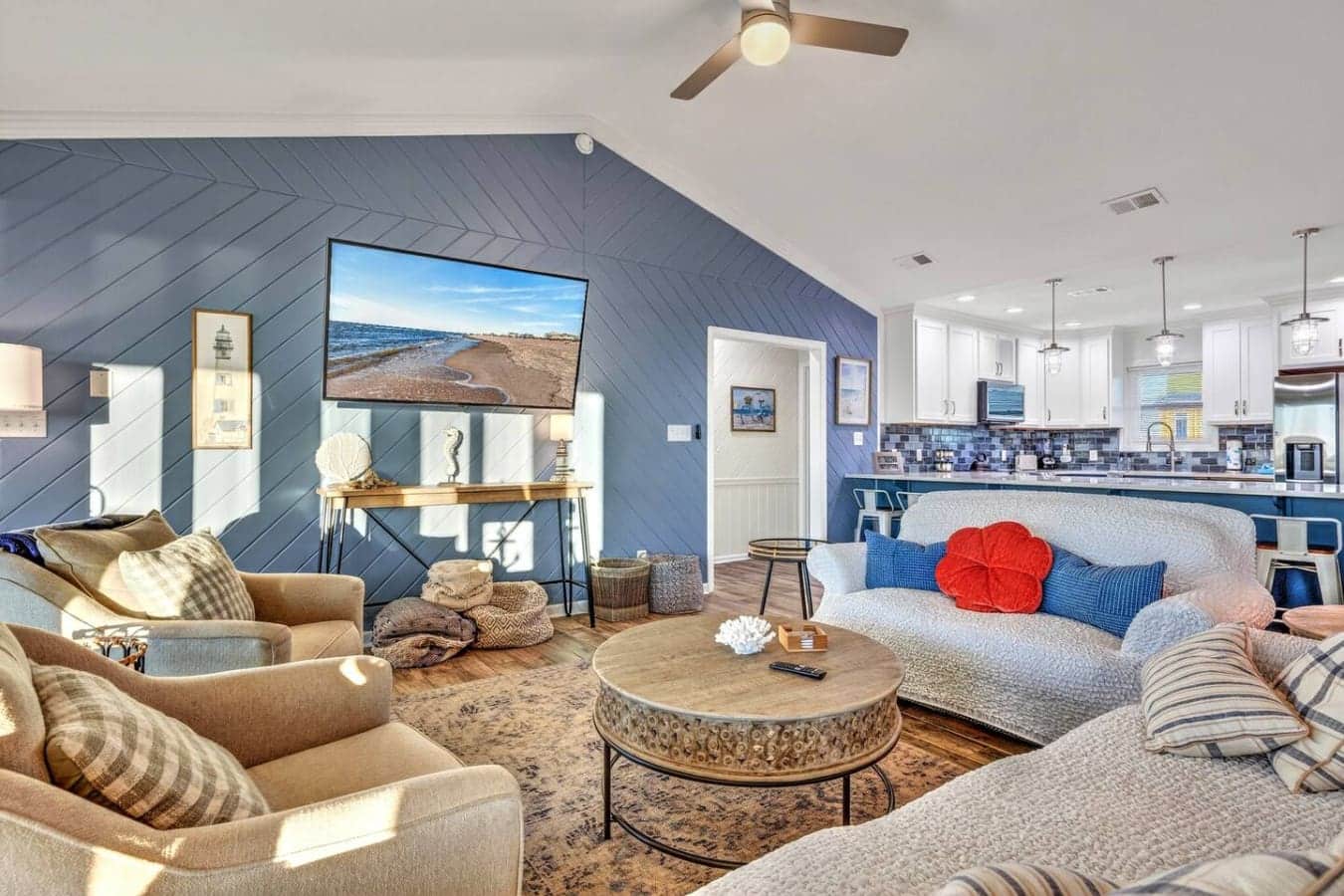 This stunning open-concept loft features a spacious living area with coastal décor, a full kitchen, and beautiful blue shiplap accents throughout.