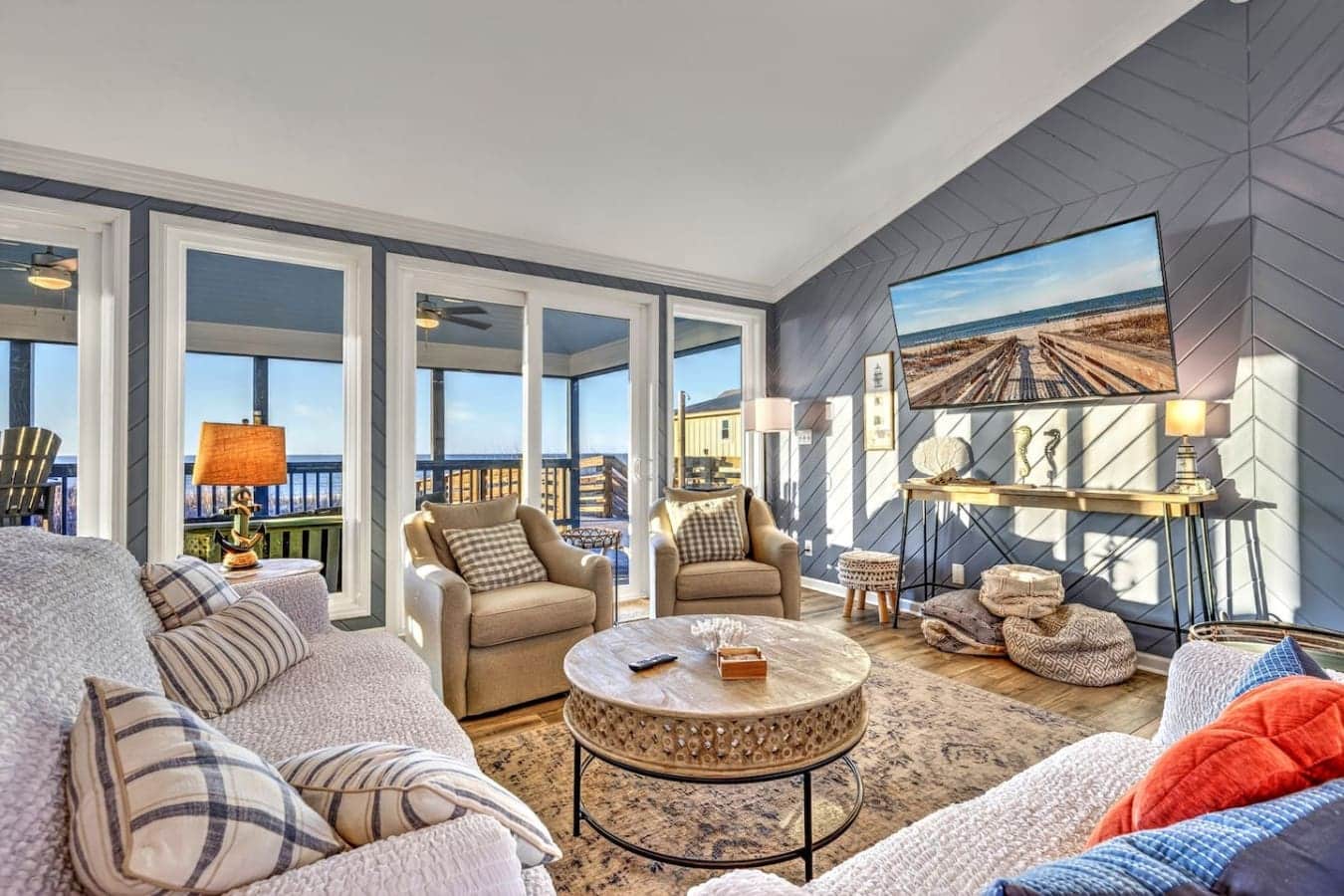 This stunning waterfront master suite features floor-to-ceiling windows, a marble coffee table, and panoramic ocean views from your private balcony.