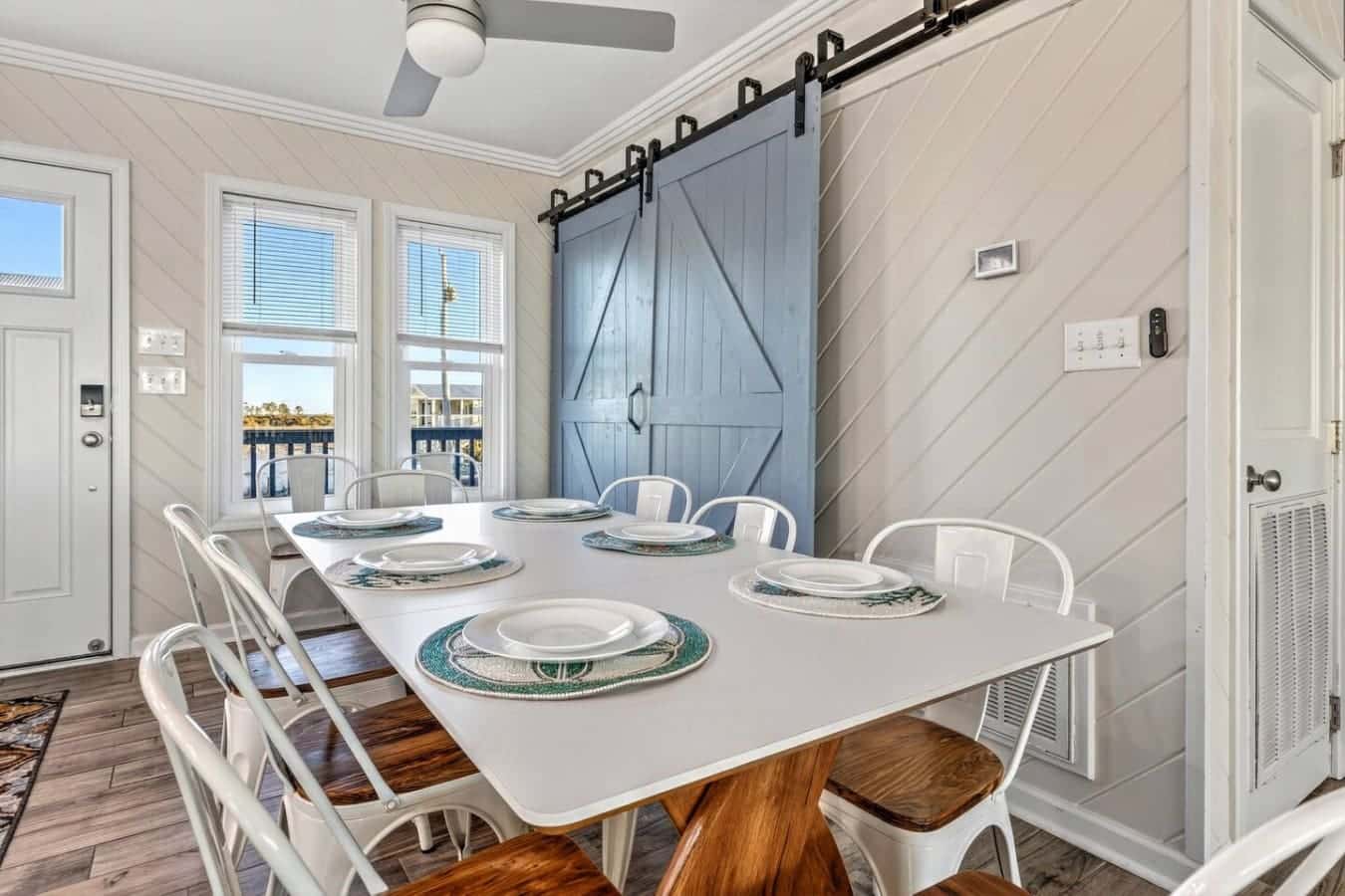 This bright dining space opens right onto a waterfront deck with those gorgeous barn doors adding some serious coastal charm.