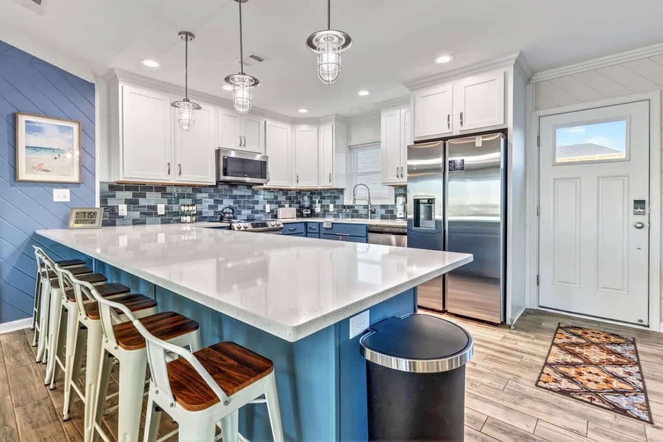 This stunning coastal kitchen features a sprawling island, stainless steel appliances, and ocean views perfect for gathering.