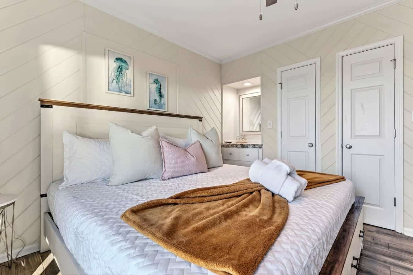 Bright, airy bedroom with shiplap walls, an ensuite bath, and those perfect coastal vibes you're looking for.