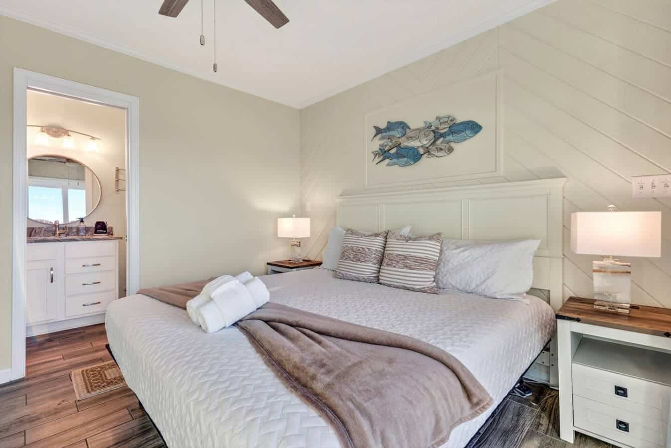 This bright coastal bedroom features a comfy king bed, an ensuite bathroom, and those vaulted ceilings that just feel amazing.