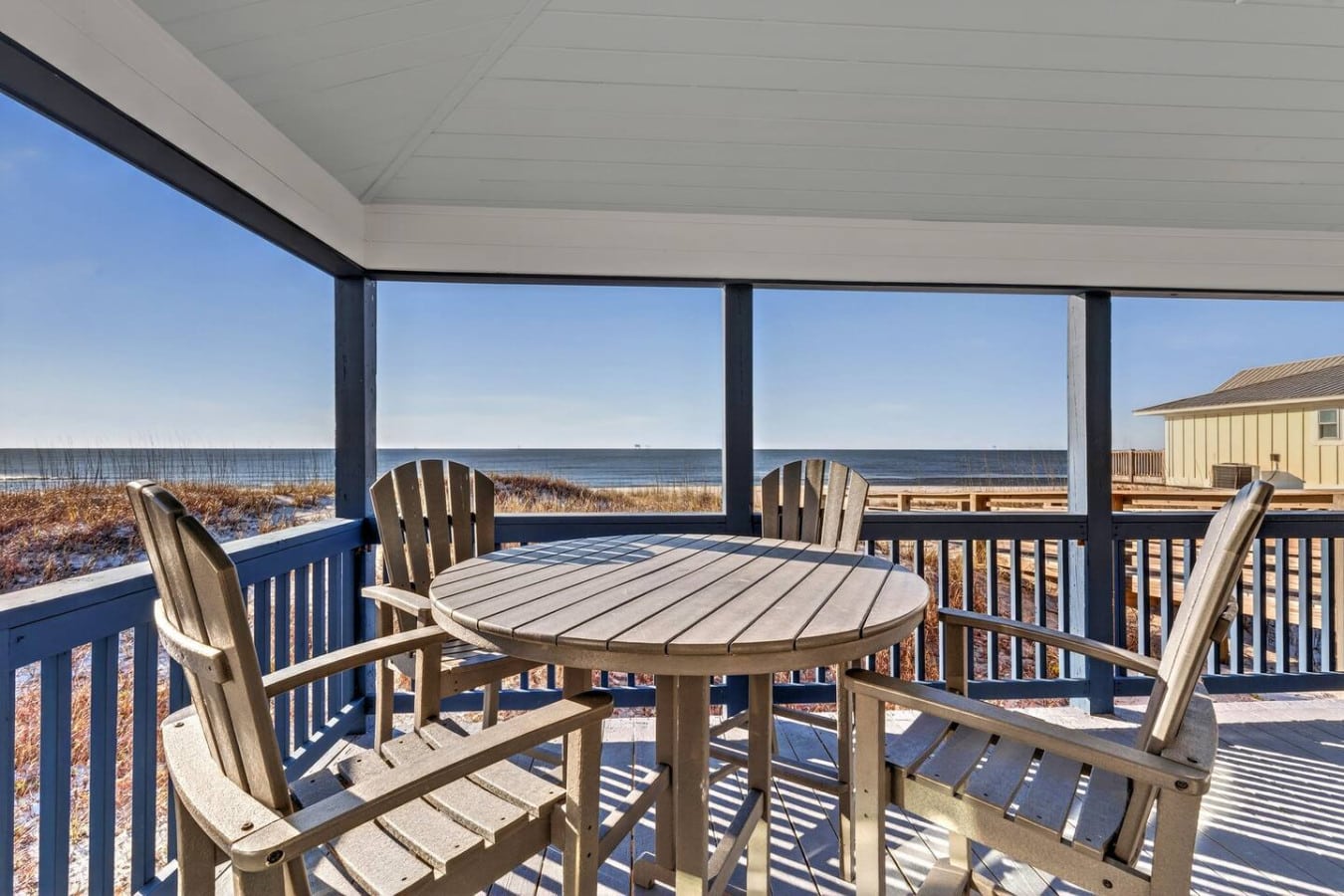 Oceanfront covered deck with Adirondack chairs and endless beach viewsu2014basically paradise if you never want to leave.