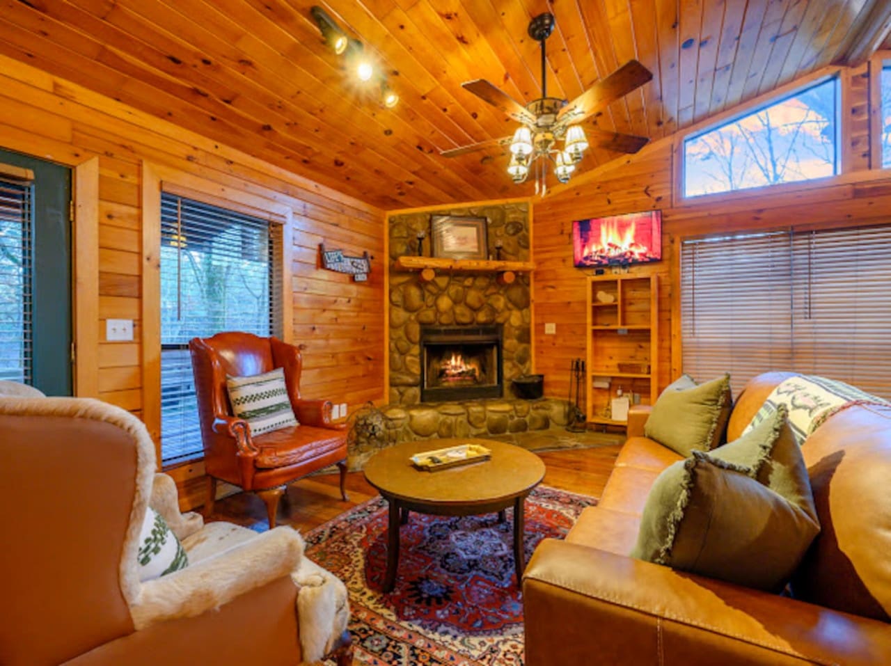 This cozy cabin living room has everything you need to unwind—fireplace, comfy seating, and a flat-screen TV.
