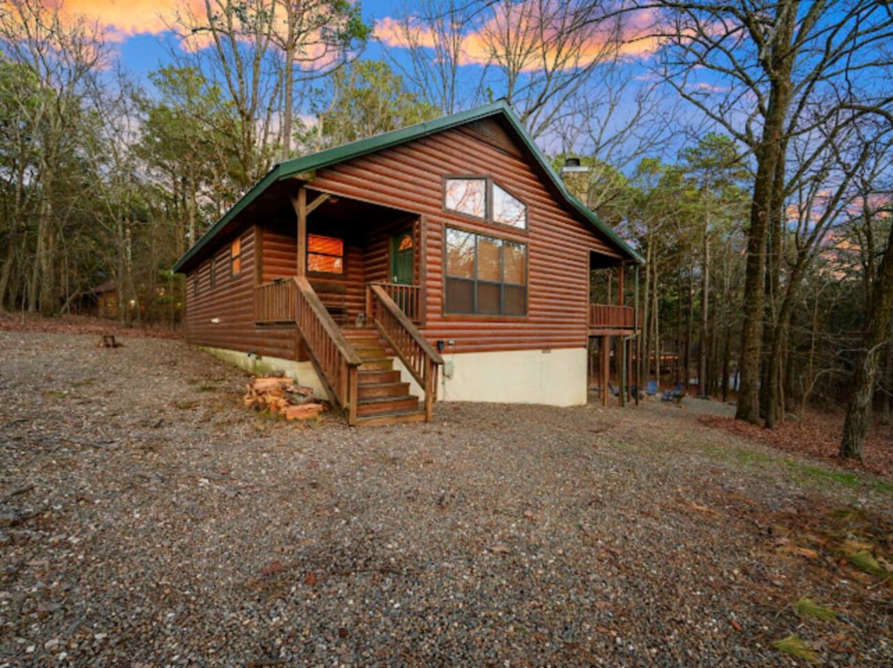 Cozy log cabin nestled in the woods with a spacious deck and modern windows overlooking nature.