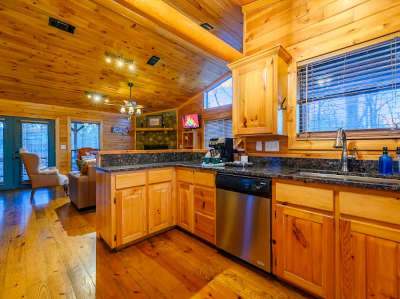 This gorgeous log cabin kitchen has it all with granite counters, stainless steel appliances, and soaring wood ceilings.