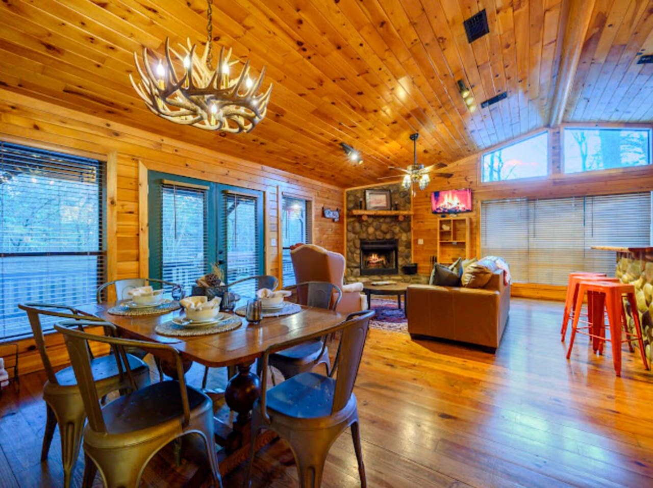 This gorgeous open-concept cabin has soaring wood ceilings, a cozy fireplace, and tons of natural light from every angle.