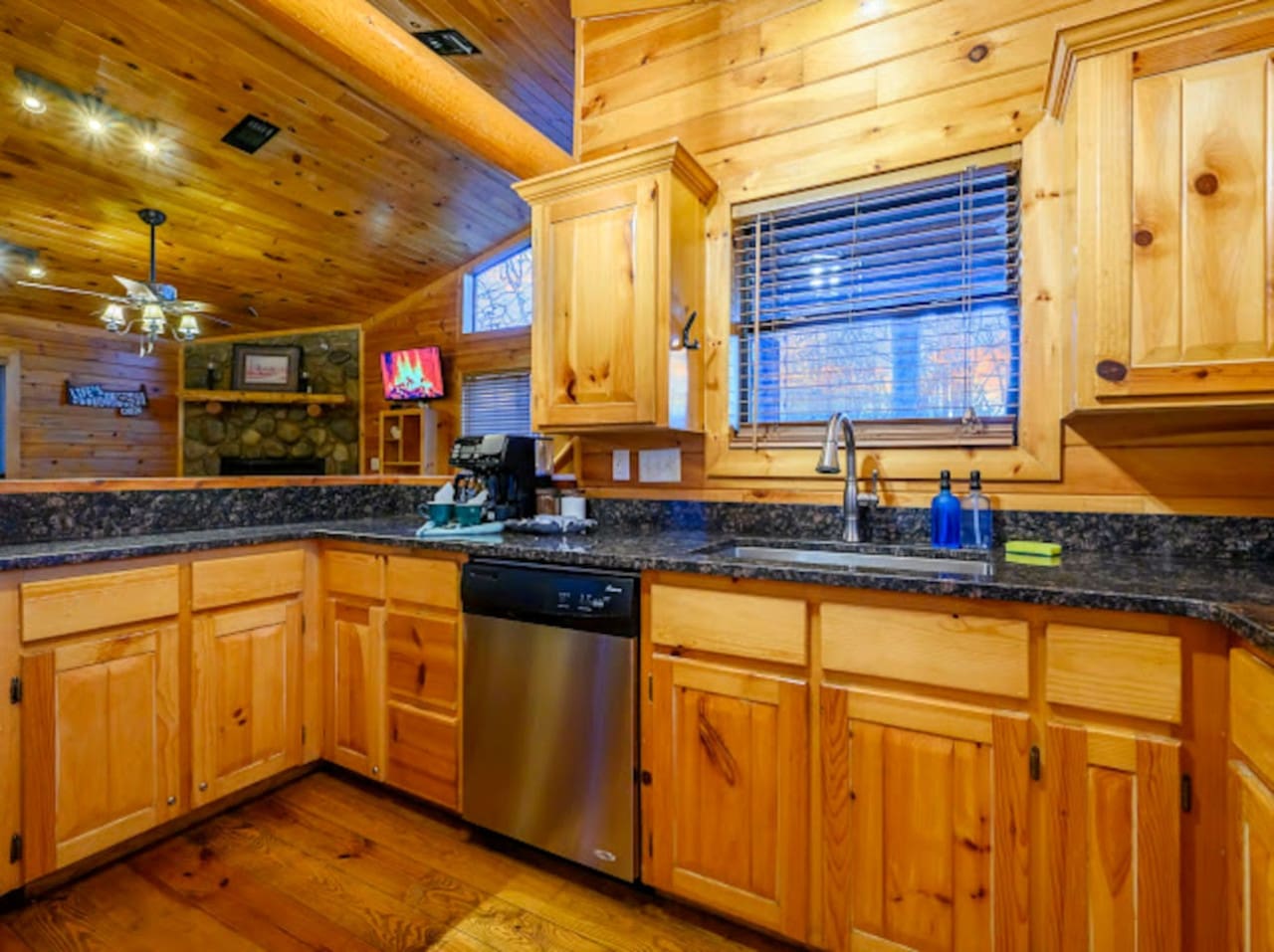 This cozy log cabin kitchen has everything you need with granite counters, stainless steel appliances, and beautiful mountain views.